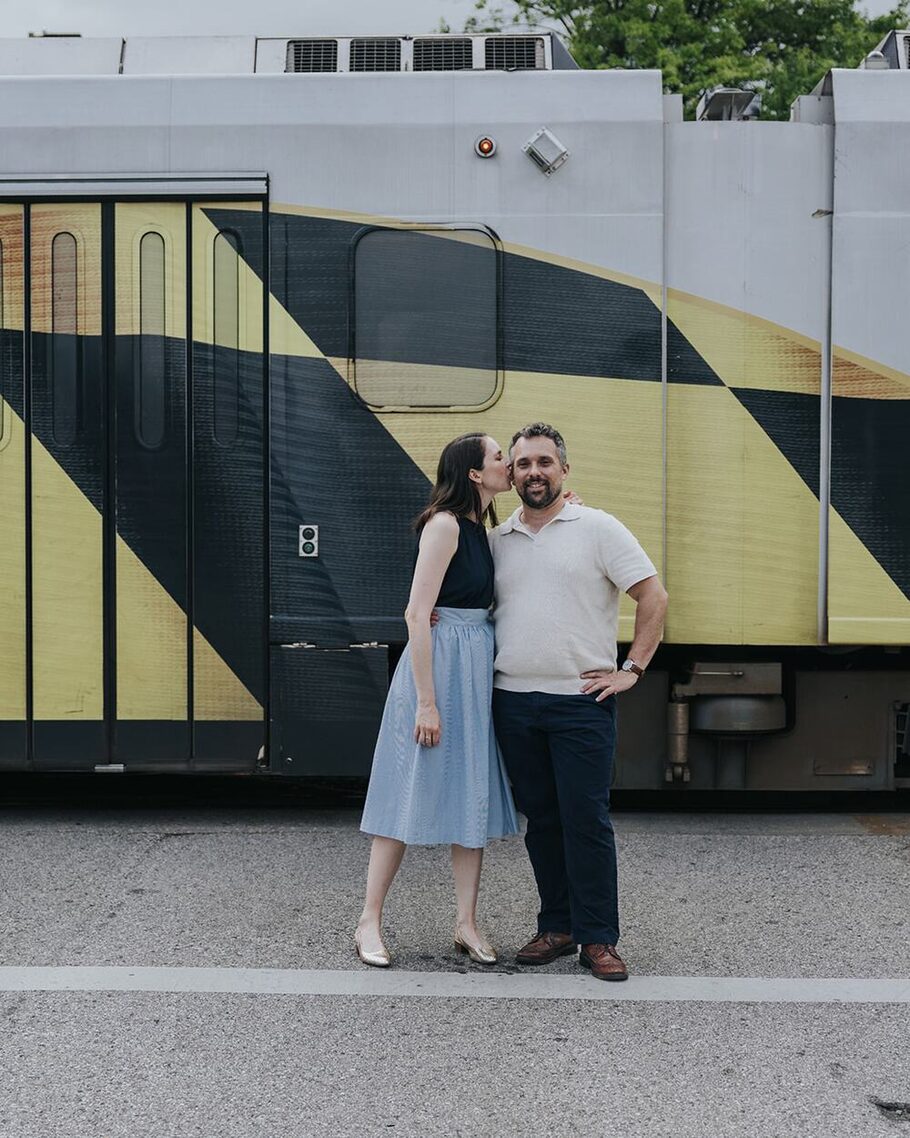 Ben and Shannon in front of a Baltimore Light RailLink car painted in the Maryland flag