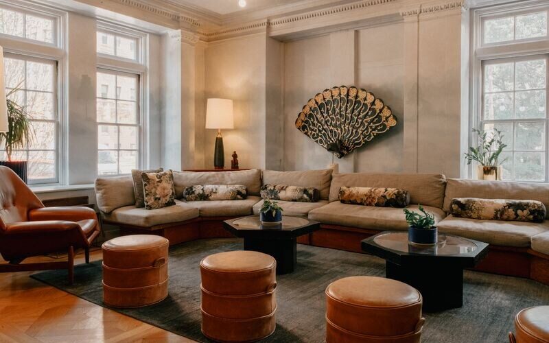 The lounge at Hotel Revival, with a gilded deco fan above a long sofa and herringbone floors