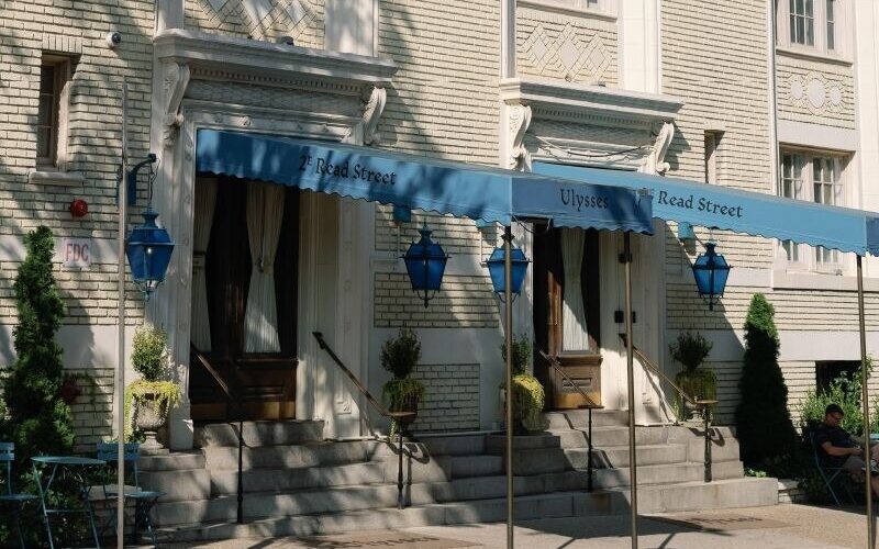 The pale brick facade of Hotel Ulysses on Read Street, under pale blue awnings